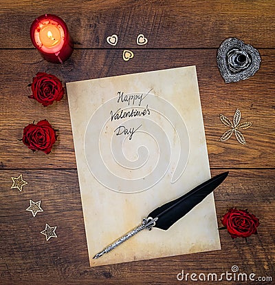 Vintage Valentine`s Day card with red roses, wooden decorations, red candle and ink and quill on vintage oak - top view Stock Photo